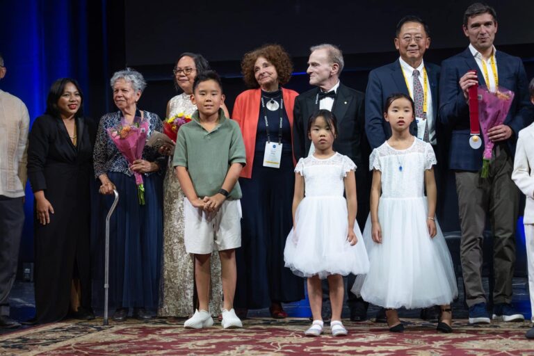 Medalists and their families gather on stage at the close of the 2026 Pioneer Medal Ceremony
